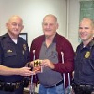 Men present books to first responders